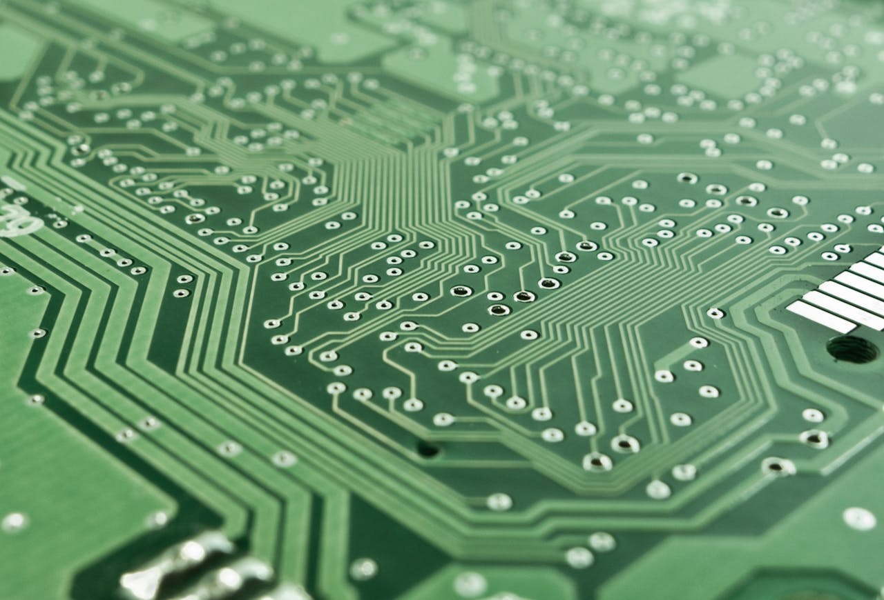 Detailed view of a green circuit board with complex patterns and pathways.